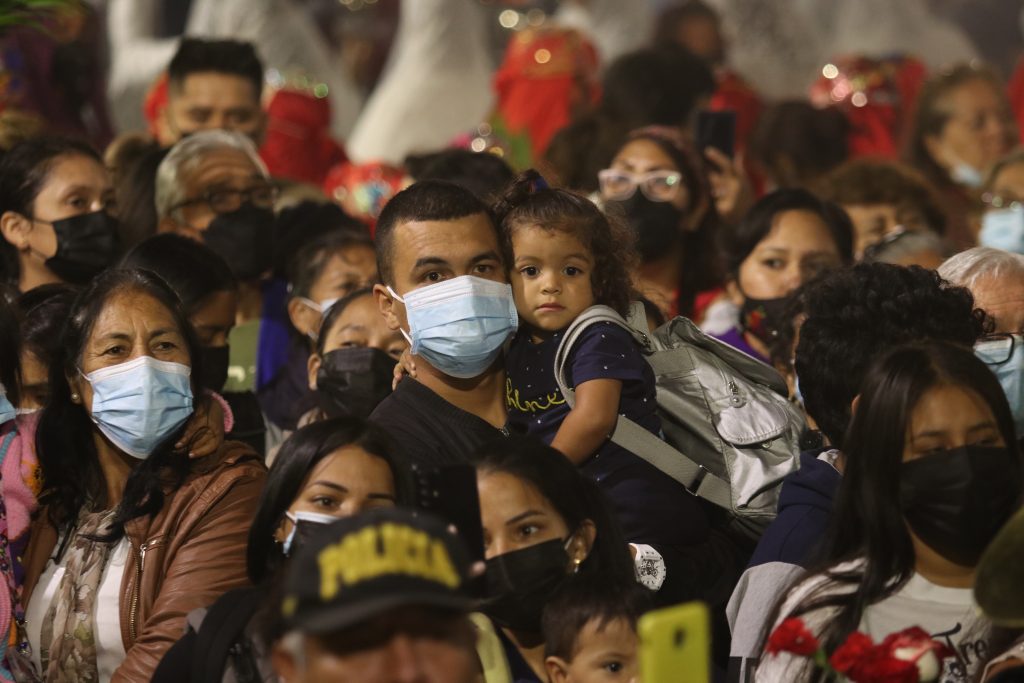 Un padre con su pequeño hijo acompañaron a la sagrada imagen del Señor de los Milagros en su recorrido por la Plaza de Armas de Trujillo. (Foto: Ivan Orbegoso).