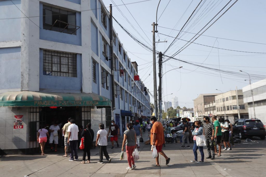 Personas forman fila para ingresar a una panadería en el distrito de La Víctoria durante el toque de queda. (Foto: Andina).
