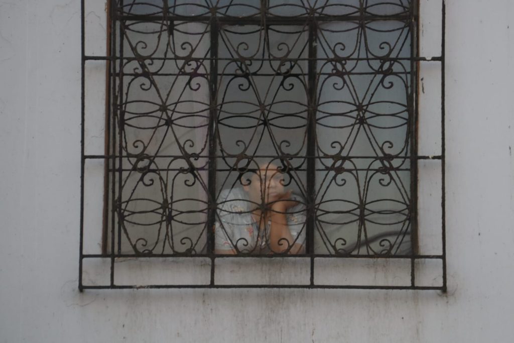 Desde la ventana de su vivienda, una mujer observa el desarrollo de la marcha. (Foto: Iván Orbegoso C.). 