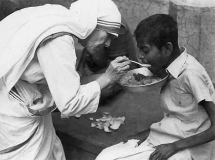 Sante Teresa de Calcuta alimenta a un niño pobre