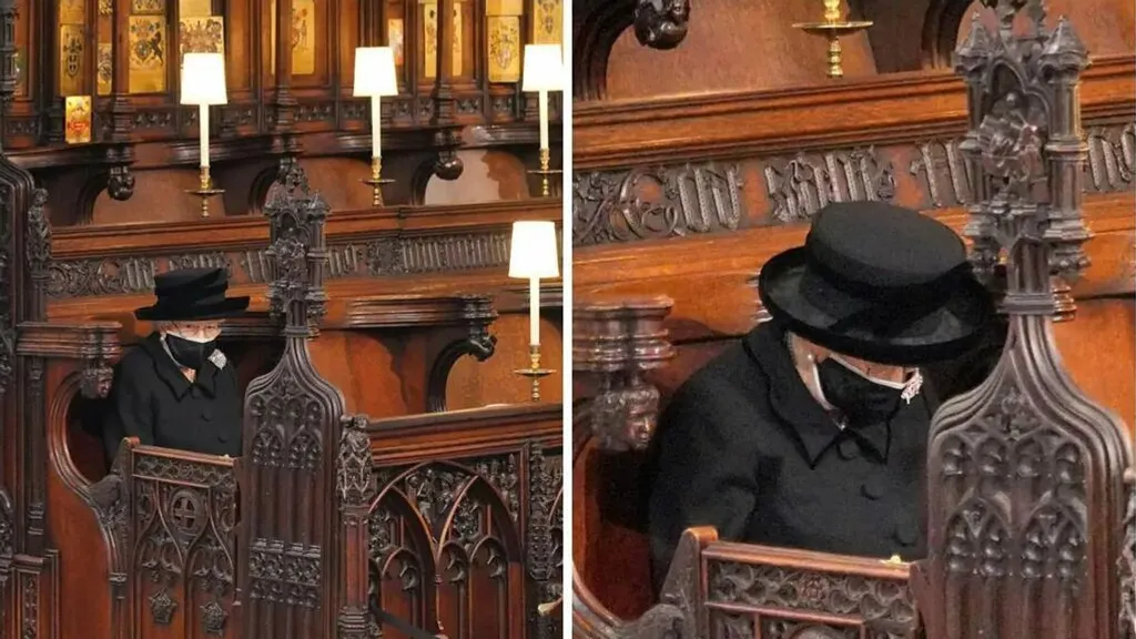 Reina Isabel con atuendo negro, sombrero negro y mascarilla.