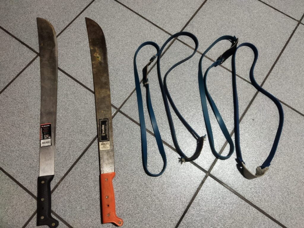 Dos cuchillos y dos lanzaderas de piedras sobre el suelo