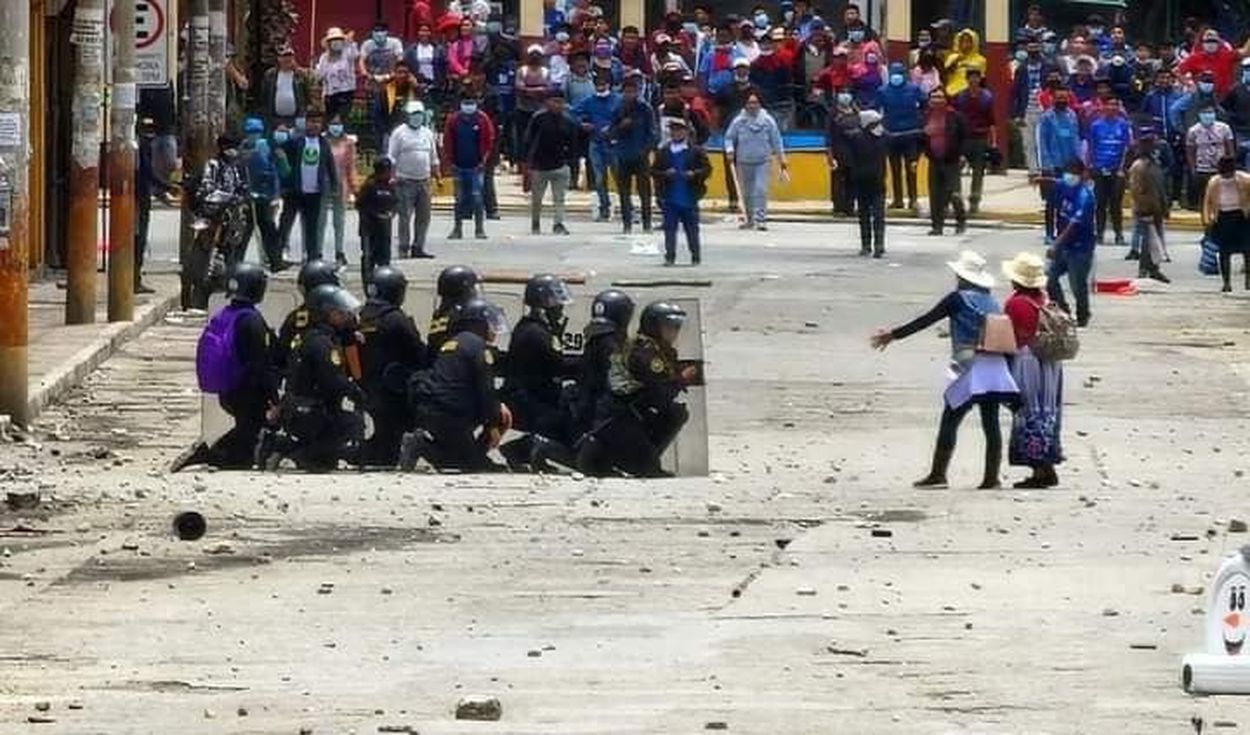 Foto La República protestas Un grupo de policías del Perú se protege son sus escudos de una turba de personas.
