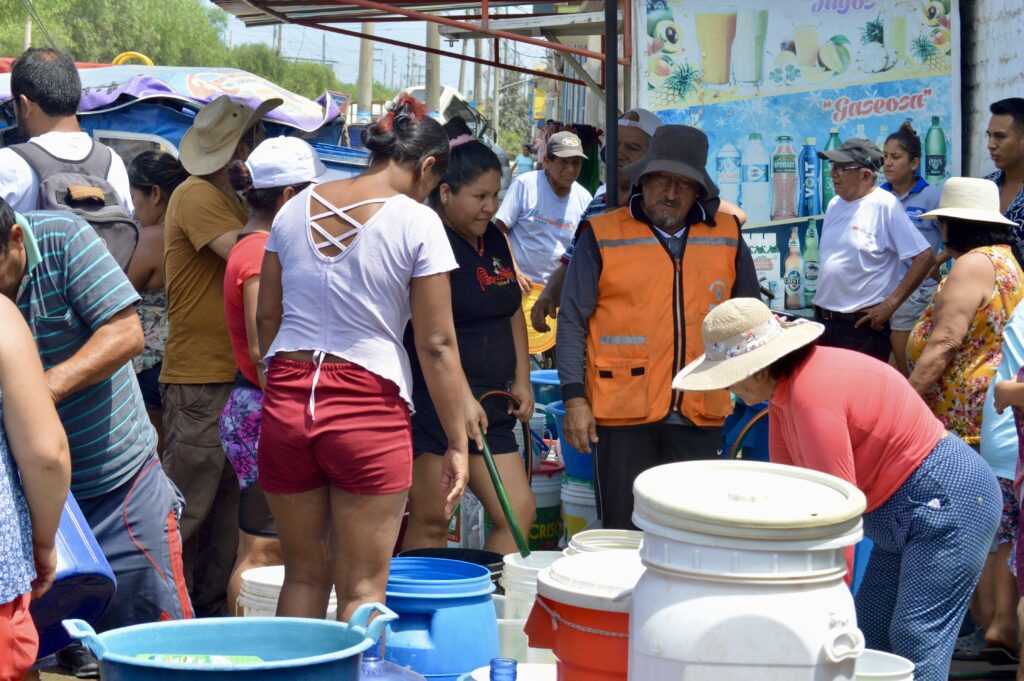 Grupo de pobladores forman una fila para esperar su turno para llenar sus cilindros debido a la falta de agua