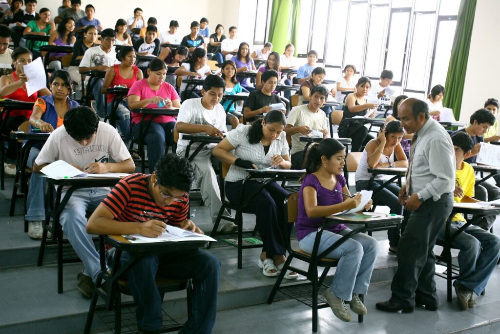 Un grupo de estudiantes rinde un examen. Un profesor se acerca a una joven. El ChatGPT lo está cambiando todo. La educación se siente interpelada con esta tecnología. (Foto: Andina).