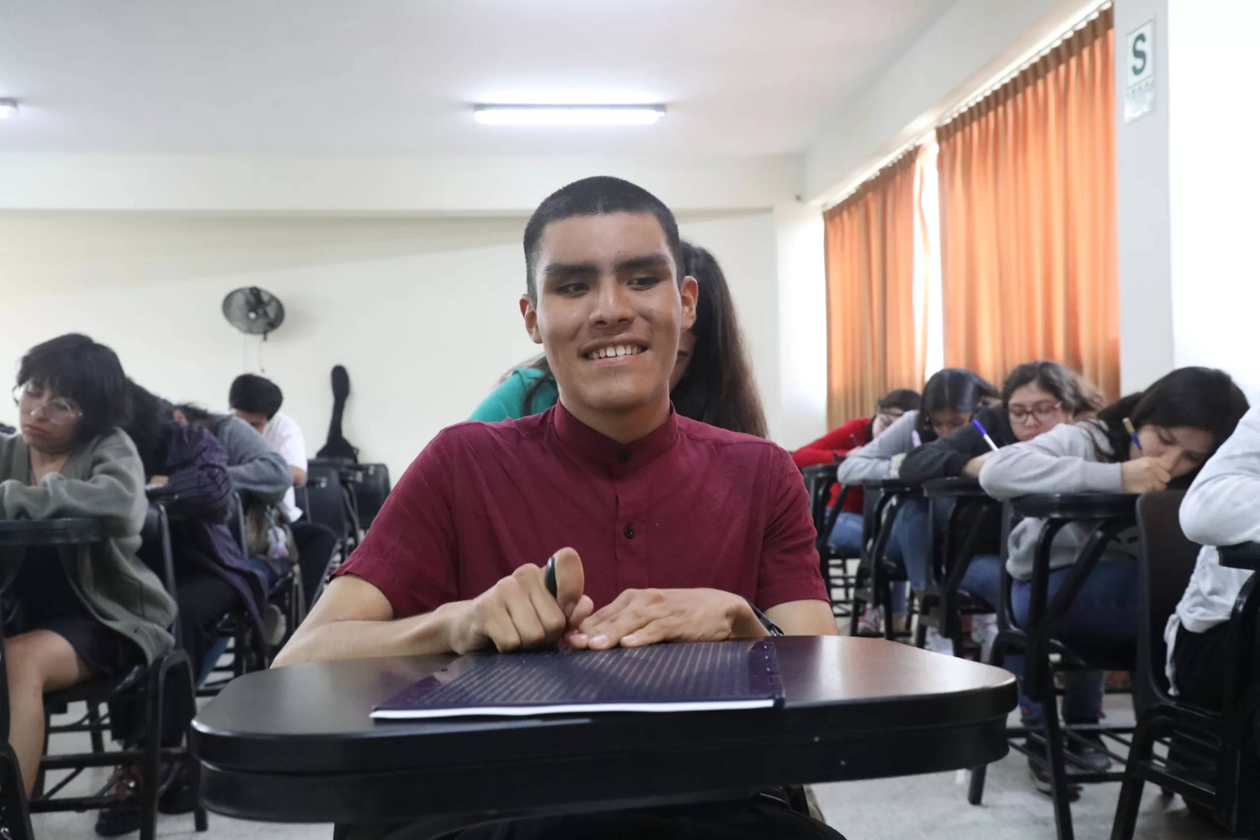 Anghelo Vera es una estudiante invidente. Se la ve mirando a la cámara en una aula de la UNiversidad Privada Antenor Orrego.