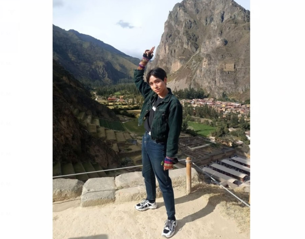 Lenin Tamayo posa en una paise andino de la sierra del Perú. El artista levante la mano. Música andina.