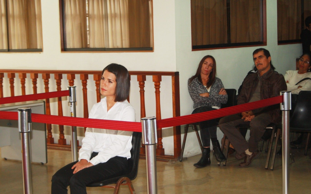 Eva Bracamonte esperar la sentencia sentada en una silla en el poder judicial del Perú. 