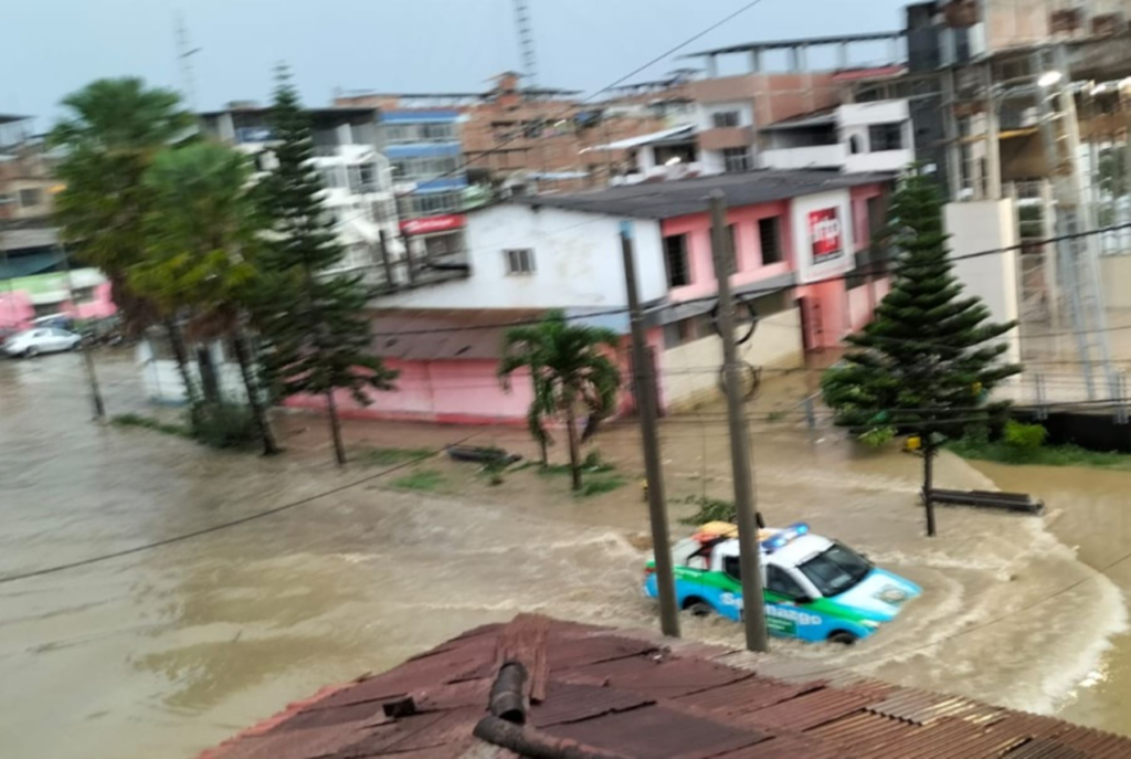 Calle de Tumbes inundada. Un vehículo intenta cruzar una calle llena de agua.
