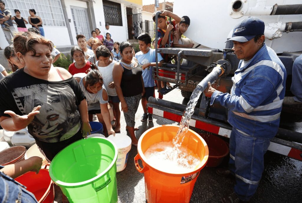 obrero reparte agua desde una cisterna. 