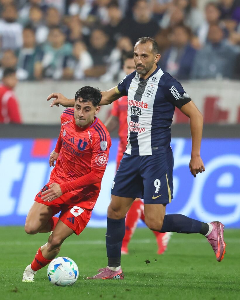 Hernán Barcos, delantero de Alianza Lima, disputa el balón con un rival de la U de Chile en el partido de ida de la Sudamericana.