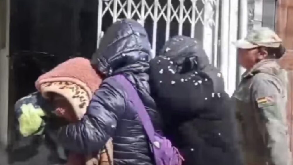 Dos mujeres peruanas son acompañadas por una policía tras quedar detenidas en Bolivia.