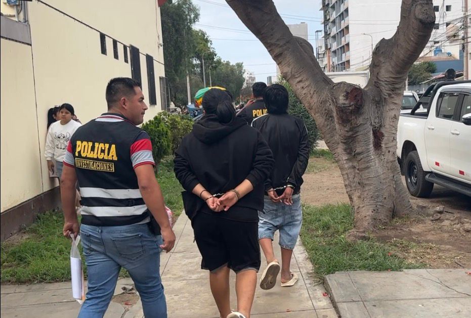 Dos menores de edad caminan esposados y escoltados por efectivos de la Policía, en Trujillo, luego de ser detenidos por cometer delitos graves.
