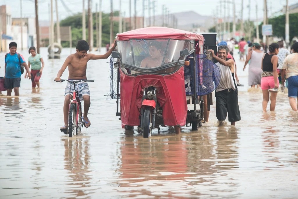 Una mototaxi avanza por una pista inundada, tras el desborde de un río, en Piura, a causa del fenómeno El Niño. 